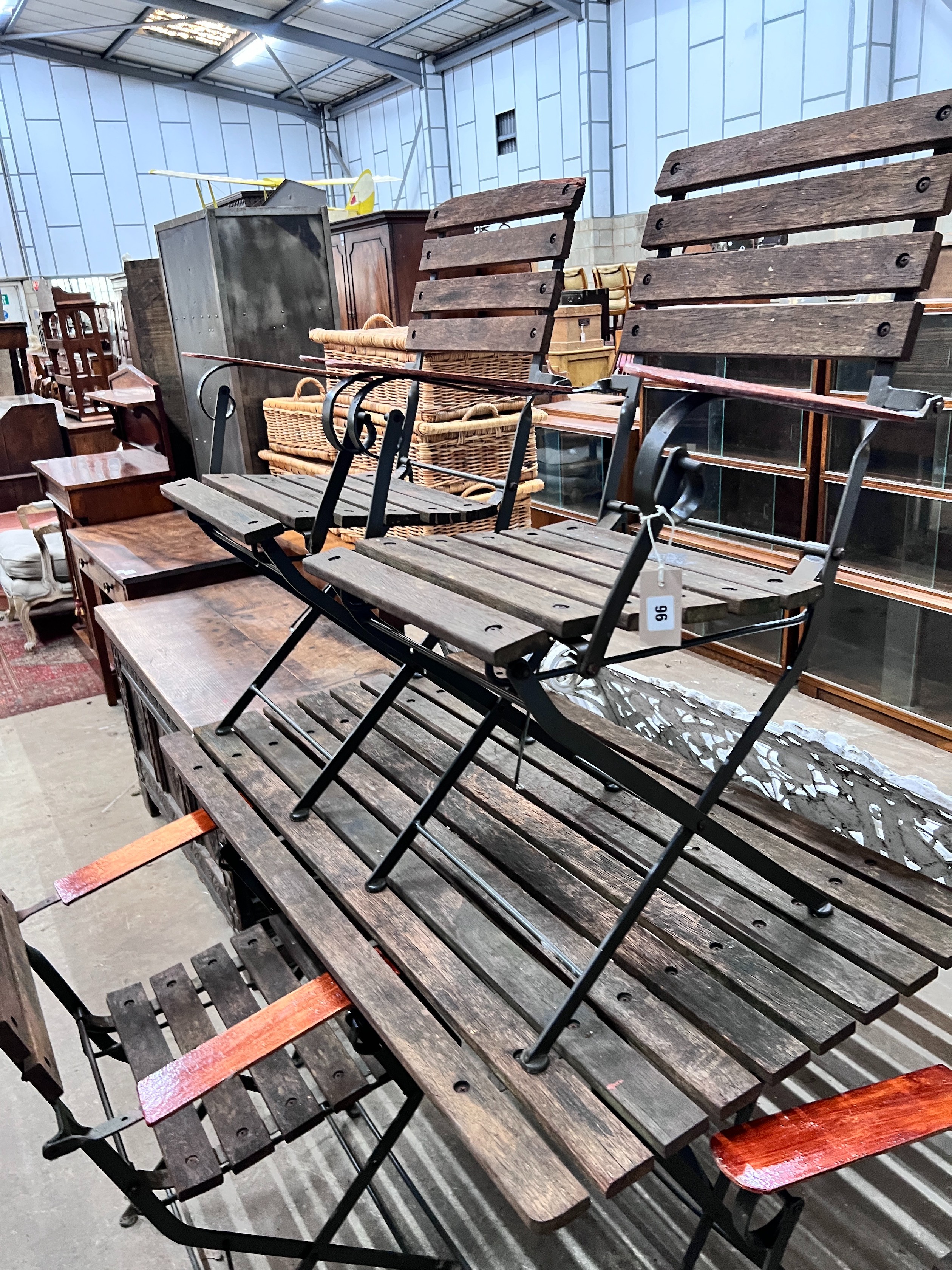 A slatted wood and wrought iron rectangular folding garden table, length 122cm, depth 68cm, height 71cm and four chairs *Please note the sale commences at 9am.